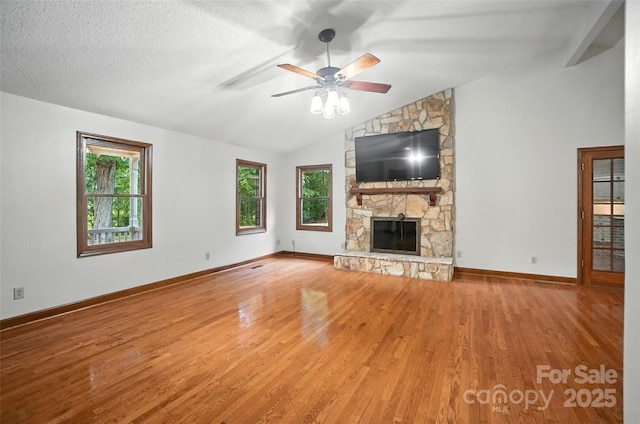 4323 Crow Rd, Monroe, NC 28112 - unfurnished living room with lofted ceiling, wood finished floors, a stone fireplace, and a ceiling fan