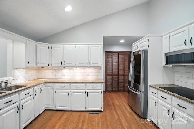 4323 Crow Rd, Monroe, NC 28112 - kitchen featuring appliances with stainless steel finishes, backsplash, light wood finished floors, white cabinetry, and recessed lighting