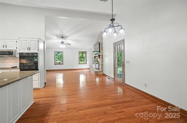 4323 Crow Rd, Monroe, NC 28112 - unfurnished dining area featuring light wood-type flooring, a ceiling fan, a chandelier, and lofted ceiling