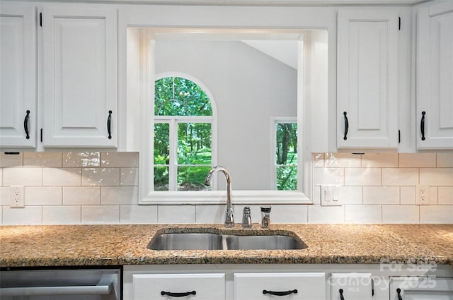 4323 Crow Rd, Monroe, NC 28112 - kitchen featuring stainless steel dishwasher, white cabinetry, tasteful backsplash, and light stone counters