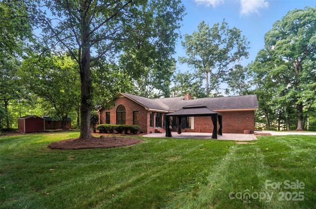 4323 Crow Rd, Monroe, NC 28112 - view of front of home featuring a gazebo, brick siding, a front yard, and a shed