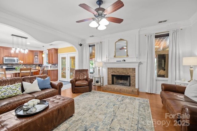 13934 Kings Carriage Ln, Charlotte, NC 28278 - living area featuring ceiling fan, light wood-style floors, a fireplace, and crown molding