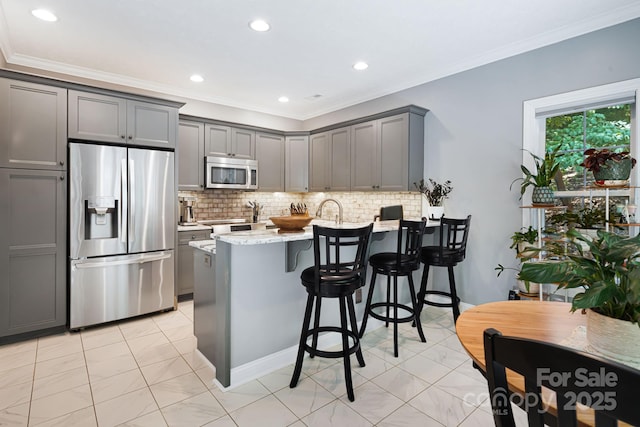 609 Carriage Commons Dr, Hendersonville, NC 28791 - kitchen with stainless steel appliances, a peninsula, gray cabinetry, tasteful backsplash, and crown molding