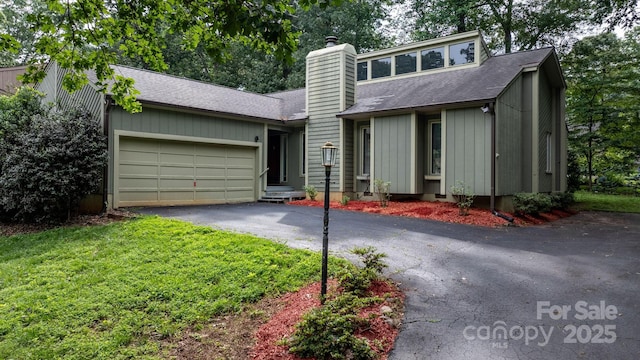 1748 4th Street Ct NE, Hickory, NC 28601 - mid-century modern home with a chimney, asphalt driveway, a garage, a shingled roof, and a front yard