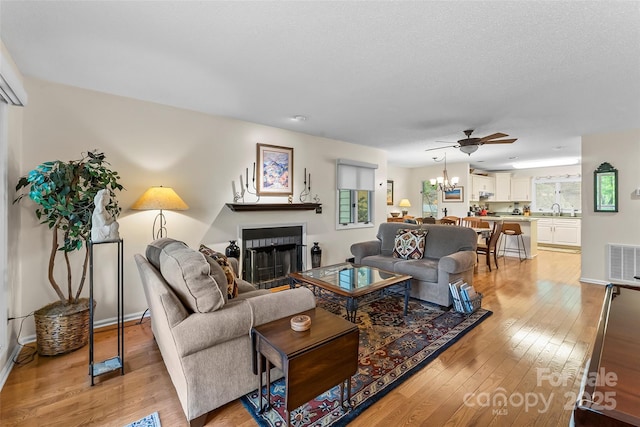 26B Cedarwood Trl, Asheville, NC 28806 - living room with a fireplace, light wood-type flooring, ceiling fan, and a chandelier