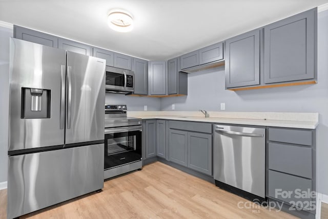 1175 Bamboo Rd, Boone, NC 28607 - kitchen featuring appliances with stainless steel finishes, gray cabinetry, light wood finished floors, and light countertops