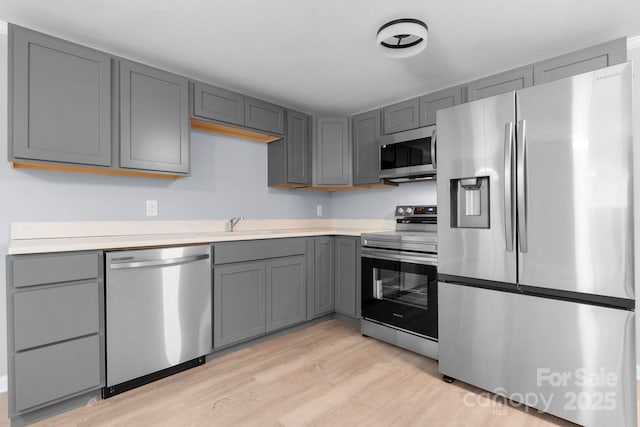 1175 Bamboo Rd, Boone, NC 28607 - kitchen with appliances with stainless steel finishes, light wood-style floors, gray cabinetry, and light countertops
