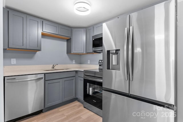 1175 Bamboo Rd, Boone, NC 28607 - kitchen featuring appliances with stainless steel finishes, gray cabinetry, light wood-style floors, and light countertops