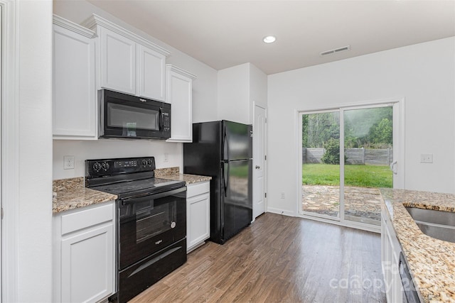 1404 Waylon Ave, Gastonia, NC 28054 - kitchen with black appliances, wood finished floors, white cabinets, recessed lighting, and light stone counters