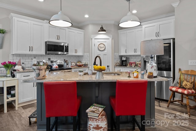 203 Poplins Grove Church Rd, Albemarle, NC 28001 - kitchen featuring appliances with stainless steel finishes, white cabinets, backsplash, a breakfast bar area, and ornamental molding