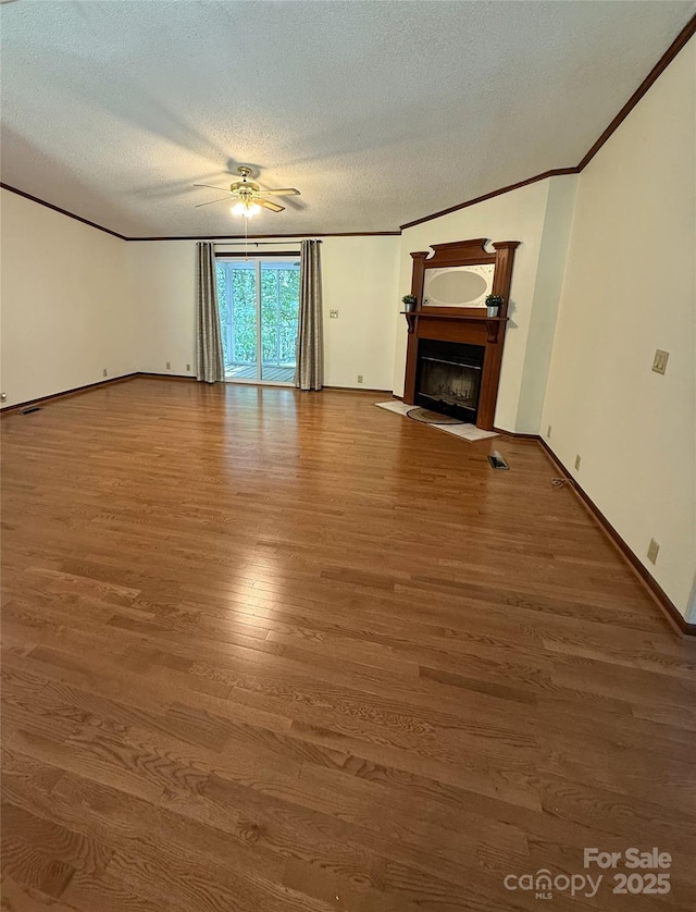 400 Archibald Rd, Concord, NC 28025 - unfurnished living room with a ceiling fan, wood finished floors, a textured ceiling, crown molding, and a fireplace with flush hearth