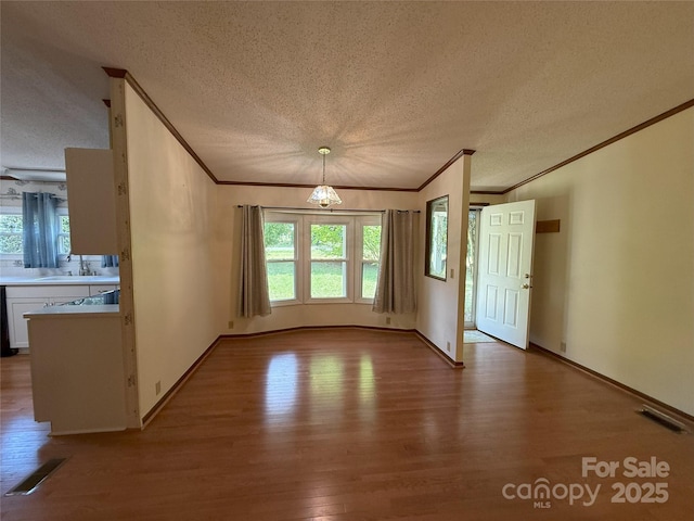 400 Archibald Rd, Concord, NC 28025 - unfurnished dining area with ornamental molding, wood finished floors, a textured ceiling, plenty of natural light, and a chandelier
