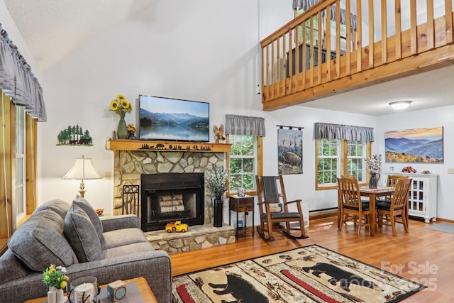 84 Hawk Nest Rd, Maggie Valley, NC 28751 - living area featuring wood finished floors, a fireplace, high vaulted ceiling, and a textured ceiling