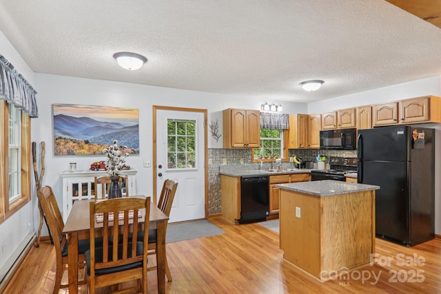 84 Hawk Nest Rd, Maggie Valley, NC 28751 - kitchen with black appliances, a kitchen island, tasteful backsplash, light wood finished floors, and baseboard heating