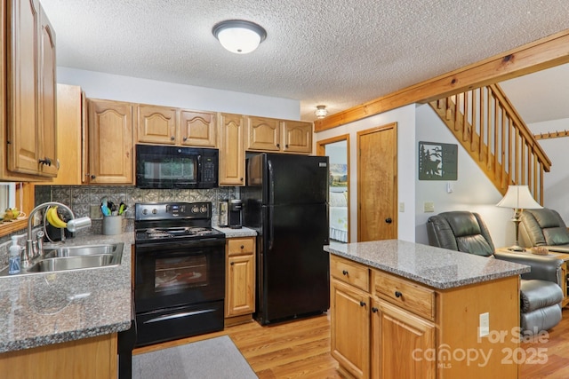 84 Hawk Nest Rd, Maggie Valley, NC 28751 - kitchen featuring black appliances, light wood-type flooring, a textured ceiling, tasteful backsplash, and a kitchen island