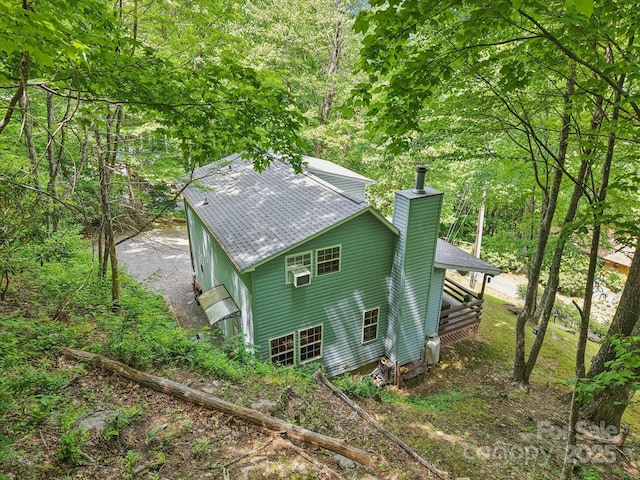 84 Hawk Nest Rd, Maggie Valley, NC 28751 - view of property exterior featuring a chimney, a shingled roof, cooling unit, and a view of trees