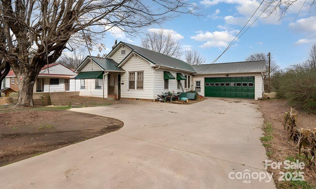 3220 Harmony Hwy, Harmony, NC 28634 - ranch-style house with concrete driveway, a metal roof, and a garage