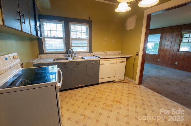 3220 Harmony Hwy, Harmony, NC 28634 - kitchen with white appliances, wooden walls, light countertops, gray cabinets, and light carpet