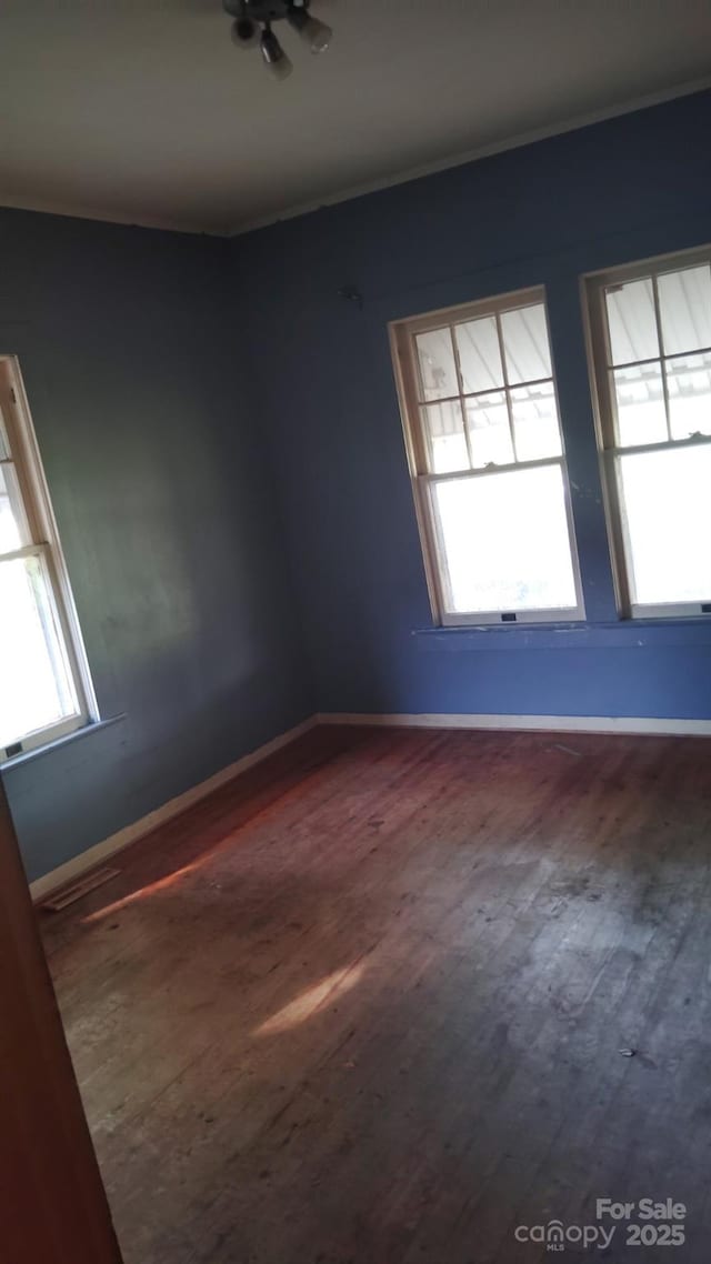 3220 Harmony Hwy, Harmony, NC 28634 - empty room with dark wood-style flooring, ornamental molding, and healthy amount of natural light