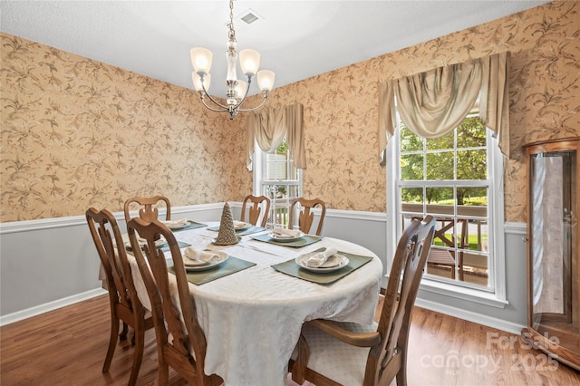 171 Highland Woods Ct, Denver, NC 28037 - dining area with wainscoting, a chandelier, wallpapered walls, wood finished floors, and plenty of natural light