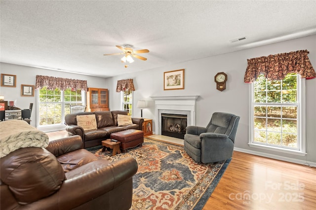 171 Highland Woods Ct, Denver, NC 28037 - living room featuring wood finished floors, ceiling fan, a fireplace with flush hearth, and a textured ceiling