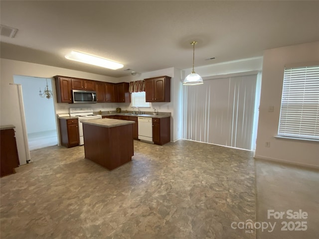 3933 Cameron Creek Dr, Matthews, NC 28105 - kitchen with white appliances, a kitchen island, light countertops, decorative light fixtures, and tile patterned floors