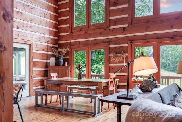 1745 Sugar Camp Rd, Marshall, NC 28753 - dining area featuring wood finished floors, wooden walls, healthy amount of natural light, and a high ceiling