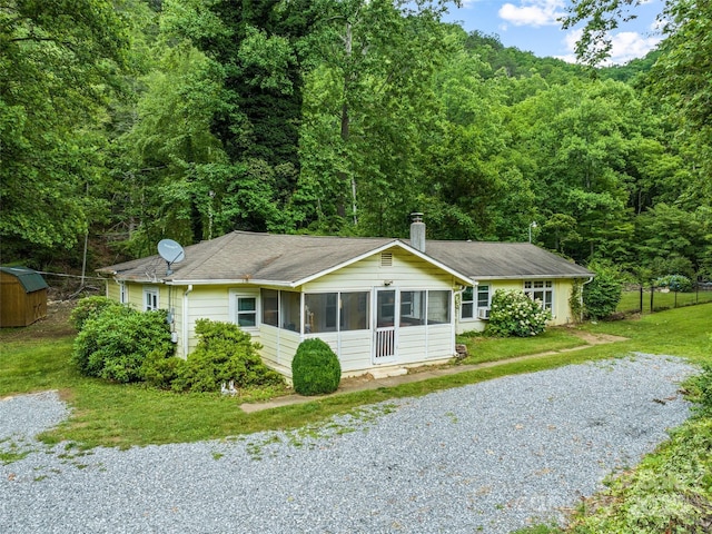 449 Little E Fork Rd, Canton, NC 28716 - ranch-style home featuring a sunroom, a forest view, a chimney, a shed, and driveway