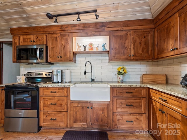 449 Little E Fork Rd, Canton, NC 28716 - kitchen featuring appliances with stainless steel finishes, backsplash, wood finished floors, and brown cabinetry