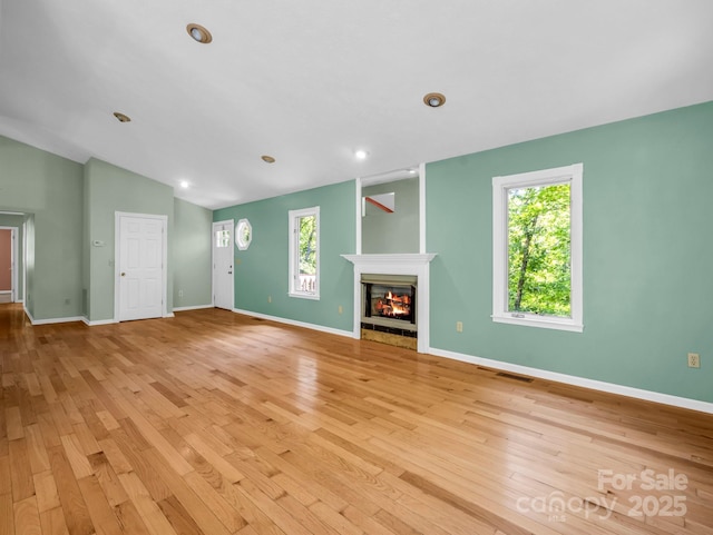 436 Utsonati Ln, Brevard, NC 28712 - unfurnished living room featuring light wood-style floors, a glass covered fireplace, vaulted ceiling, and recessed lighting