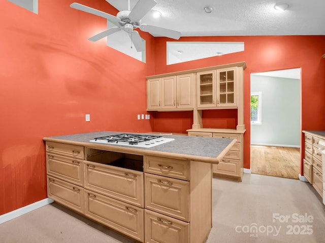 436 Utsonati Ln, Brevard, NC 28712 - kitchen with white gas stovetop, light countertops, a ceiling fan, glass insert cabinets, and high vaulted ceiling