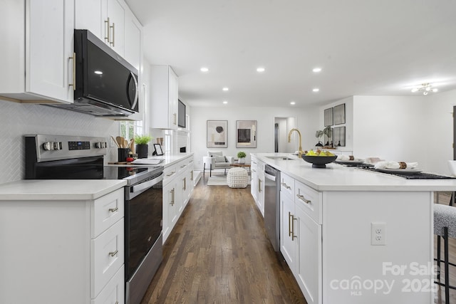 5817 Red Carriage Ln, Charlotte, NC 28212 - kitchen featuring stainless steel appliances, open floor plan, dark wood-style flooring, white cabinetry, and a breakfast bar