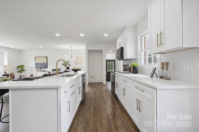 5817 Red Carriage Ln, Charlotte, NC 28212 - kitchen featuring stainless steel appliances, dark wood-style floors, a kitchen breakfast bar, white cabinets, and backsplash