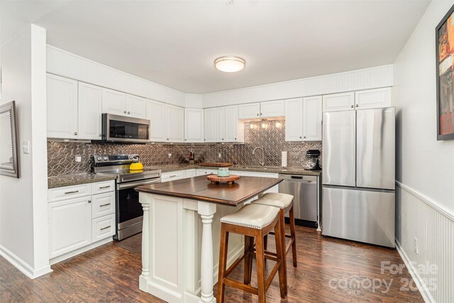 4725 Rounding Run Rd, Charlotte, NC 28277 - kitchen featuring appliances with stainless steel finishes, tasteful backsplash, white cabinetry, and dark wood-type flooring