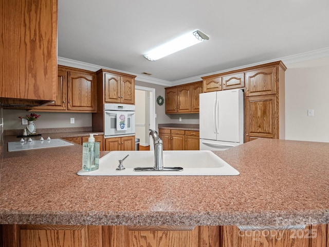2872 Wheat Field Ct, Lincolnton, NC 28092 - kitchen featuring white appliances, crown molding, brown cabinetry, light countertops, and a peninsula