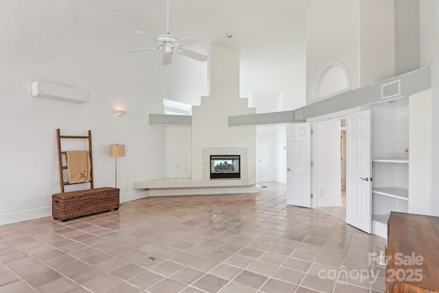 69 Sprouse Town Rd, Weaverville, NC 28787 - unfurnished living room with a towering ceiling, a wall unit AC, light tile patterned floors, ceiling fan, and a premium fireplace