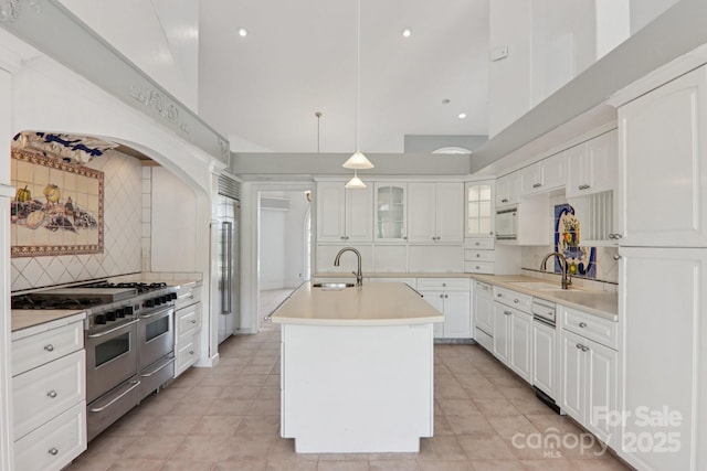 69 Sprouse Town Rd, Weaverville, NC 28787 - kitchen with double oven range, decorative backsplash, a kitchen island with sink, light countertops, and a high ceiling