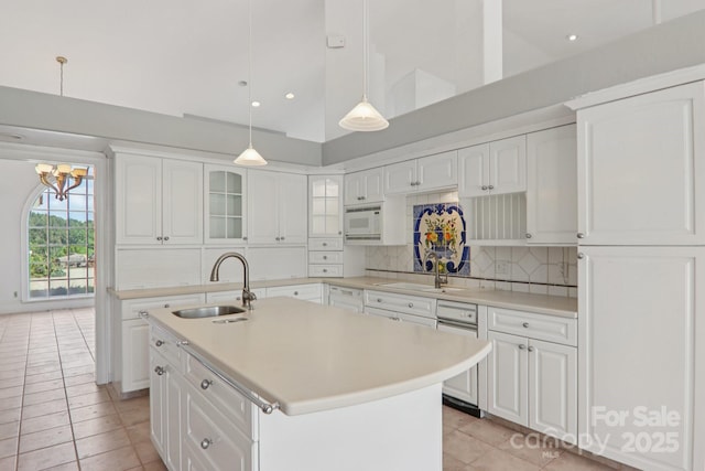 69 Sprouse Town Rd, Weaverville, NC 28787 - kitchen featuring white microwave, light tile patterned floors, light countertops, decorative backsplash, and white cabinets