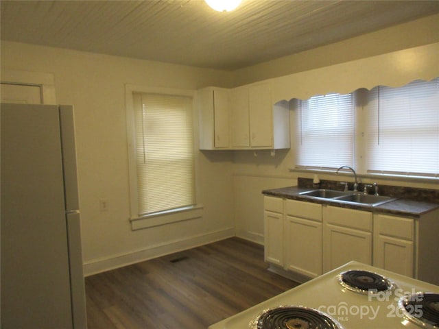 1110 20th St NE, Hickory, NC 28601 - kitchen with freestanding refrigerator, dark wood-style floors, dark countertops, and white cabinetry