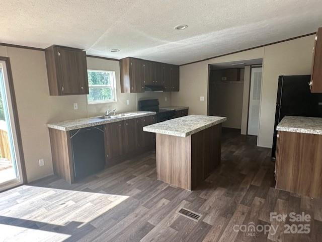 3577 Ken Mcentire Rd, Lawndale, NC 28090 - kitchen featuring a textured ceiling, dark wood-style flooring, light countertops, a center island, and exhaust hood