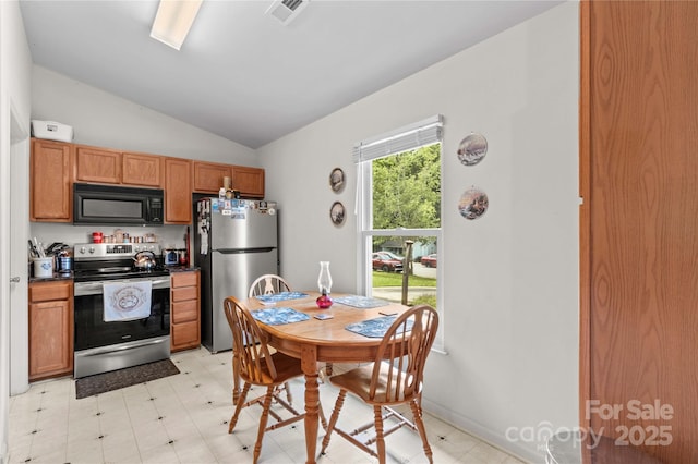 428 Mountview Dr, Mocksville, NC 27028 - kitchen with stainless steel appliances, light flooring, lofted ceiling, dark countertops, and brown cabinetry