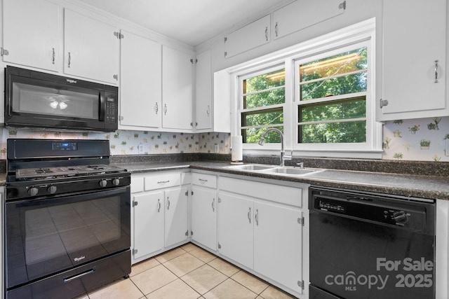 917 Sunset Ave SW, Valdese, NC 28690 - kitchen with black appliances, dark countertops, light tile patterned floors, and white cabinetry