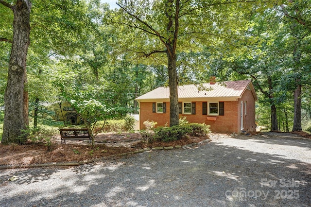 9763 Pine Tree Rd, Norwood, NC 28128 - ranch-style house with a chimney, brick siding, a metal roof, and driveway