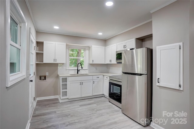 9763 Pine Tree Rd, Norwood, NC 28128 - kitchen featuring appliances with stainless steel finishes, open shelves, white cabinets, ornamental molding, and light wood finished floors