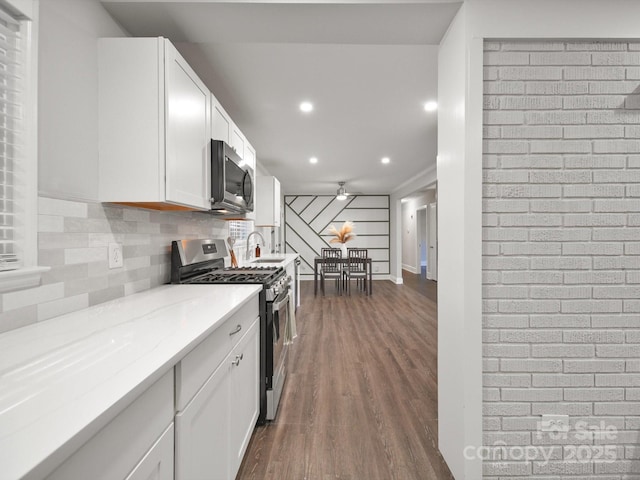 6401 Montpelier Rd, Charlotte, NC 28210 - kitchen with appliances with stainless steel finishes, dark wood finished floors, white cabinets, recessed lighting, and light stone countertops