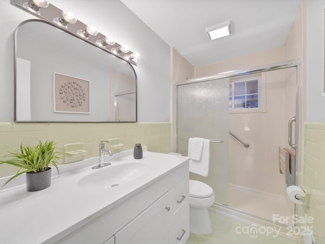 6401 Montpelier Rd, Charlotte, NC 28210 - bathroom featuring tile walls, vanity, a shower stall, tile patterned flooring, and a wainscoted wall