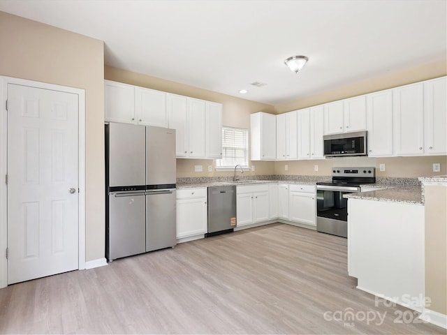 3043 Streamlet Way, Monroe, NC 28110 - kitchen with stainless steel appliances, light wood finished floors, white cabinetry, light stone counters, and recessed lighting