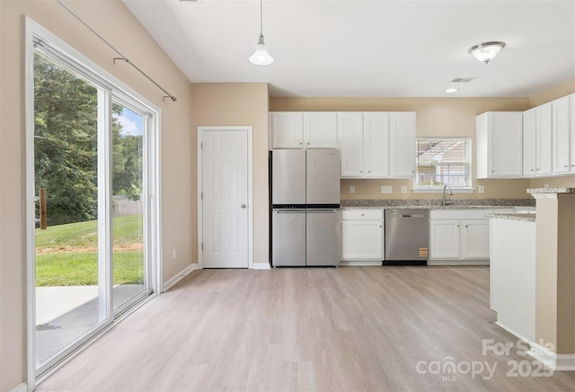 3043 Streamlet Way, Monroe, NC 28110 - kitchen featuring appliances with stainless steel finishes, light wood-style flooring, plenty of natural light, and white cabinets