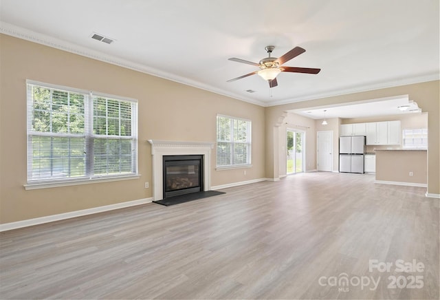 3043 Streamlet Way, Monroe, NC 28110 - unfurnished living room featuring ceiling fan, light wood-style floors, crown molding, and a glass covered fireplace