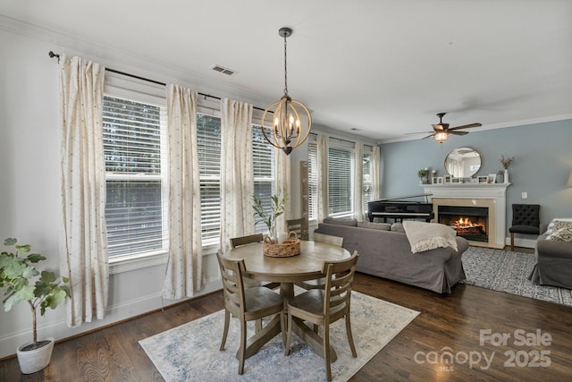 347 Bayberry Creek Cir, Mooresville, NC 28117 - dining room with a ceiling fan, a warm lit fireplace, crown molding, wood finished floors, and a chandelier